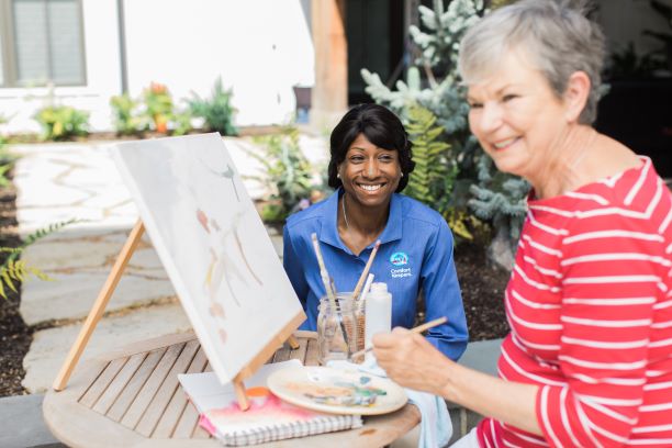 Caregiver painting with senior resident as part of her Interactive Caregiving