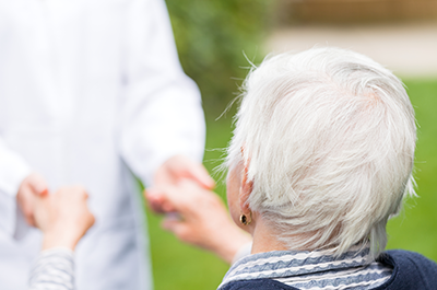 senior and caregiver holding hands outside in dana point ca