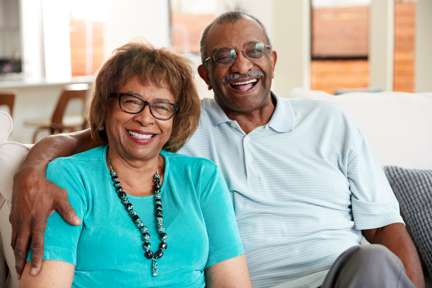 African American couple sitting on sofa smiling