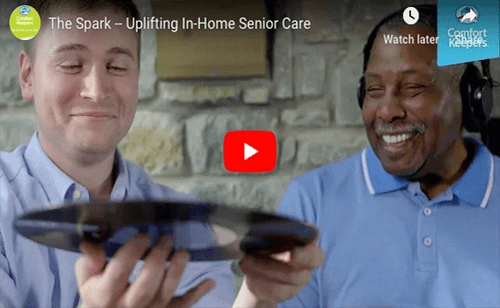 Screenshot of video with caregiver and senior listening to music and holding a record