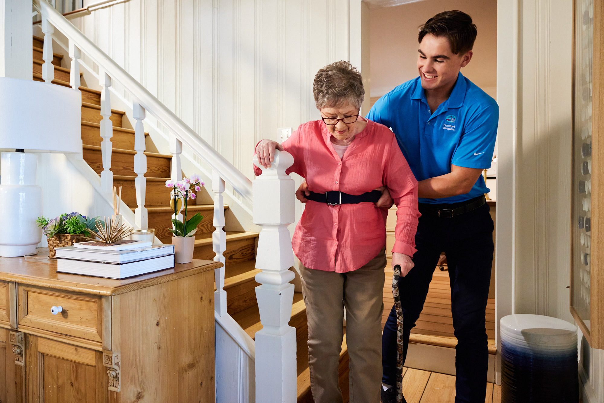 A Comfort Keepers Caregiver assists a woman walking using a gait belt