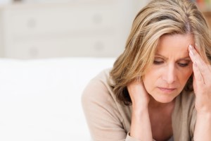 Female caregiver suffering from stress rubbing temple