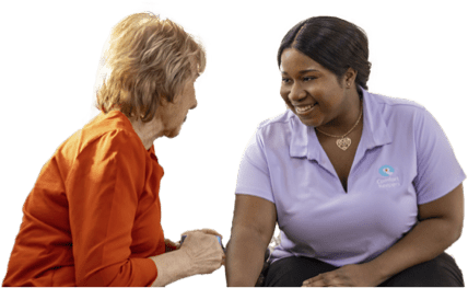 Caregiver and client smiling while sitting together and talking