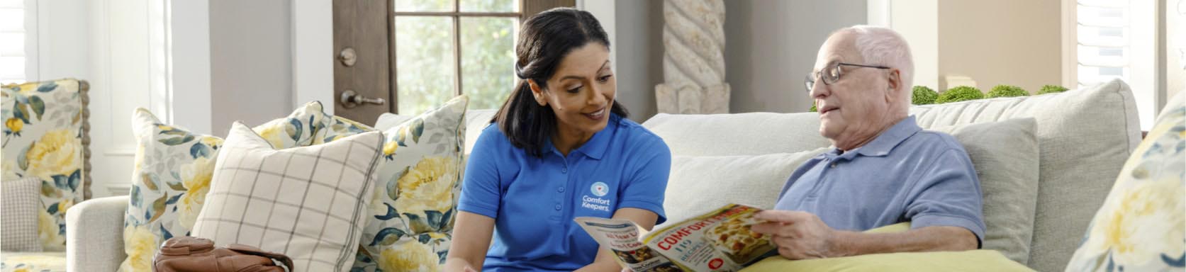 Caregiver and client reading a magazine and talking