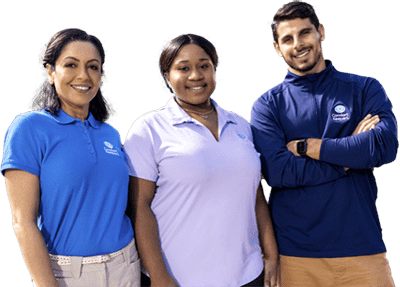 Three caregivers stand side by side while smiling for a photo