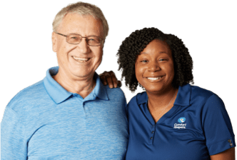 Caregiver and client standing side by side smiling