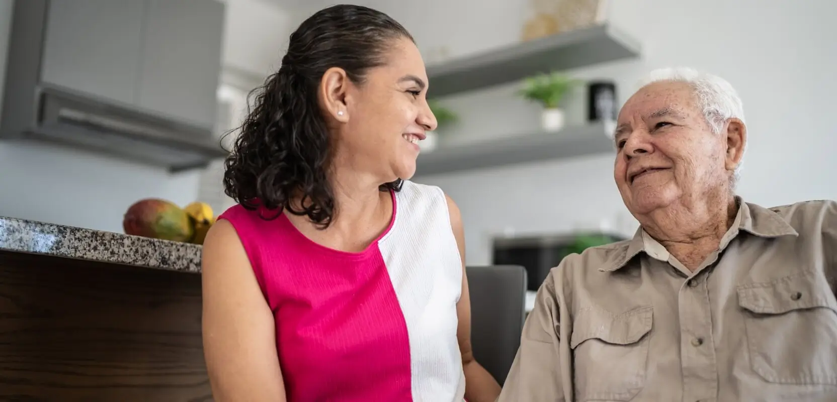 Caregiver smiling with elderly man during in home care in Stapleton