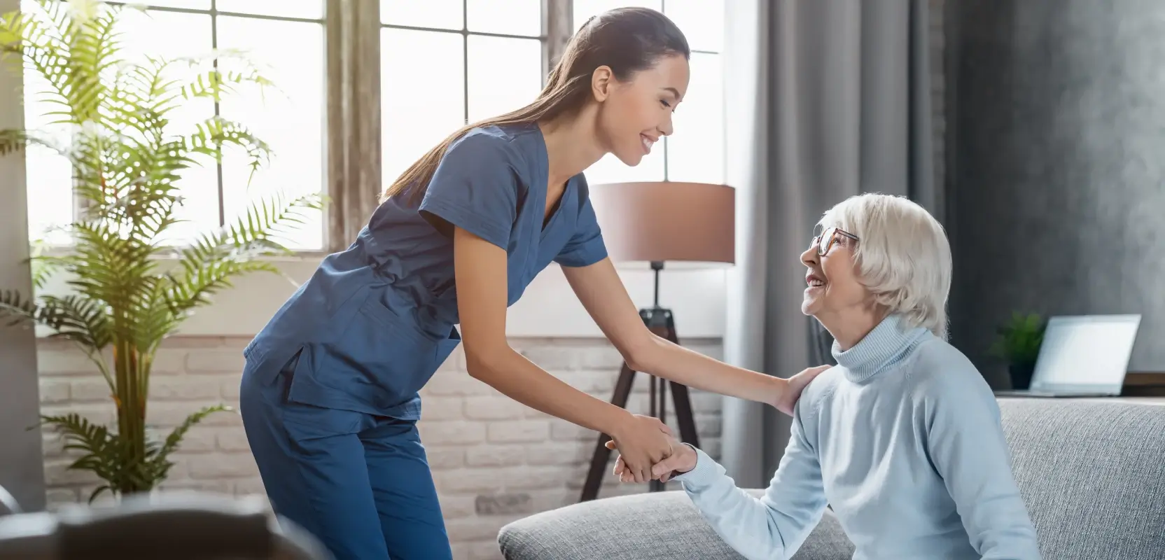 A medical professional helps a senior patient in her home.