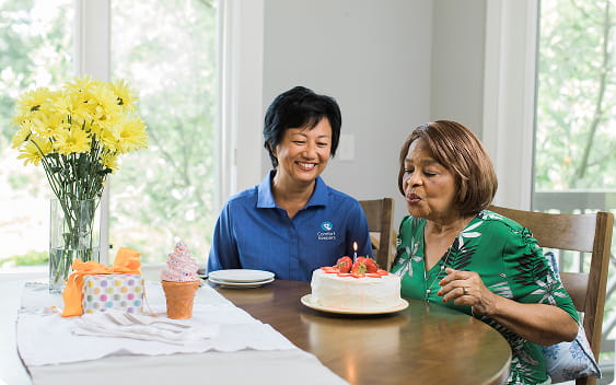 Caregiver walking client outside with walker