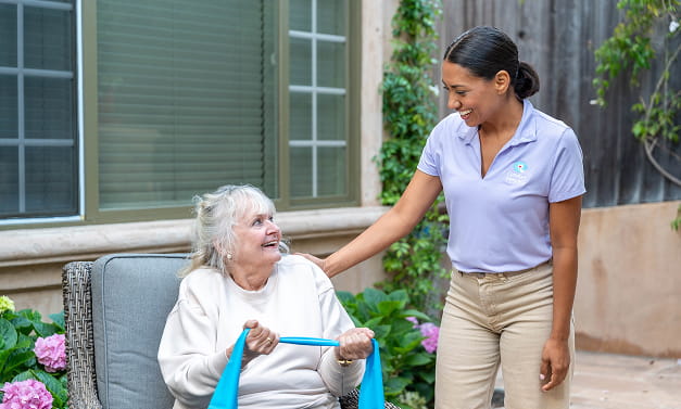 Caregiver walking client outside with walker