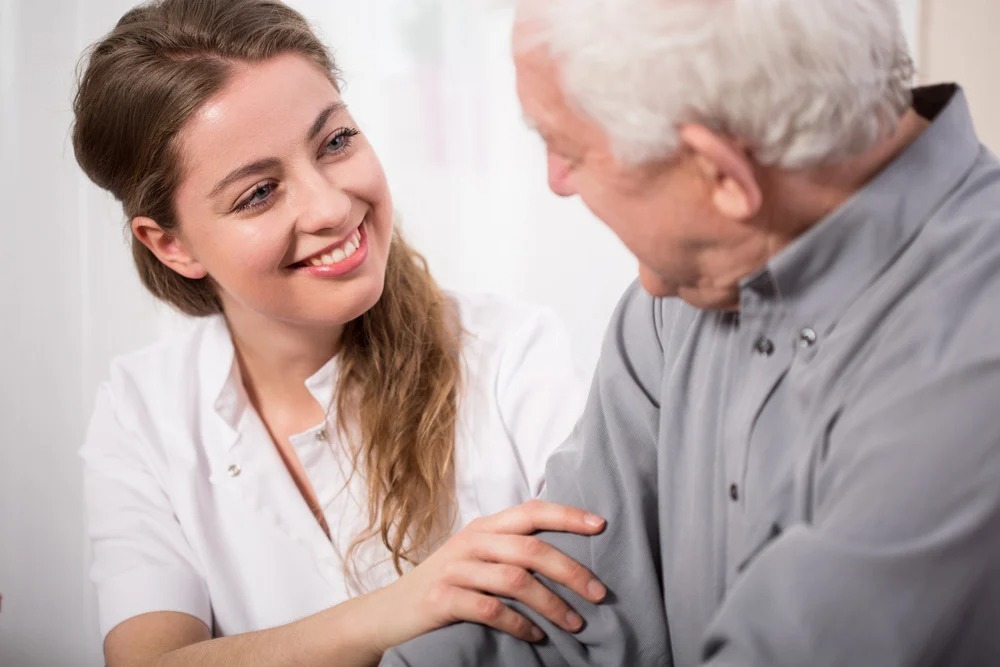 Picture of smiling nurse assisting senior man with Alzheimers