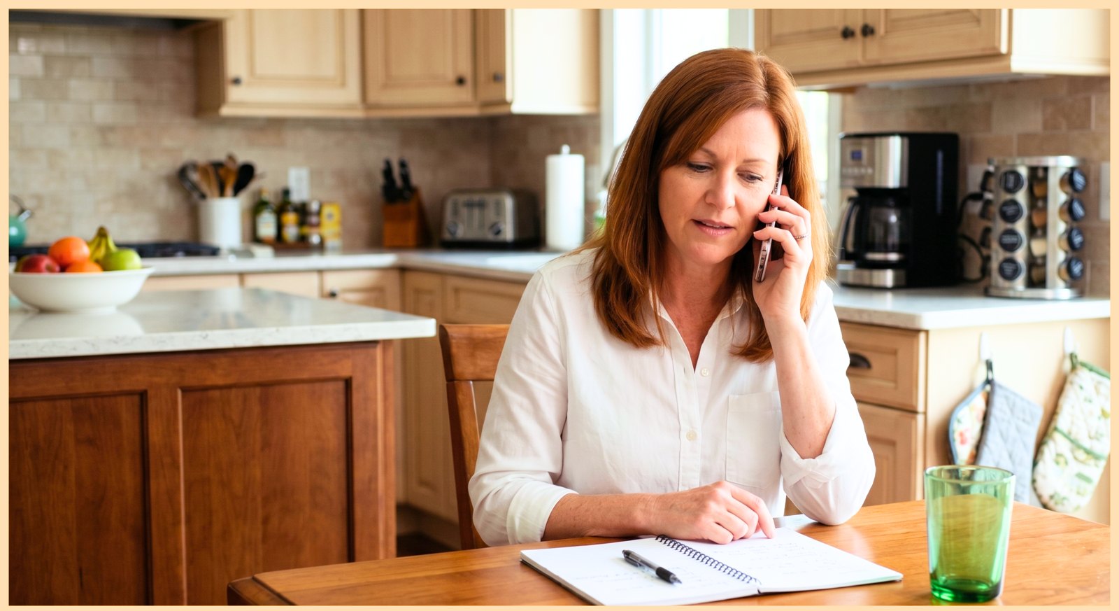 An adult daughter at her kitchen table on the phone taking notes, inquiring about home care for her parent in Edison, NJ