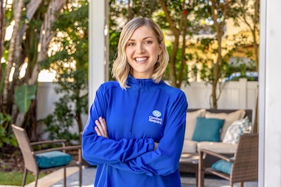 caregiver standing outside of a home with a Comfort Keepers branded jacket