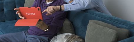 Younger man helping older man using a tablet