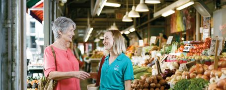 Comfort Keeper Caregiver with client selecting groceries or running errands together.