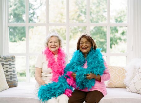 Two seniors dressing up and posing for the camera