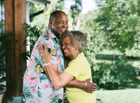 Photo of an older couple hugging and smiling while on vacation