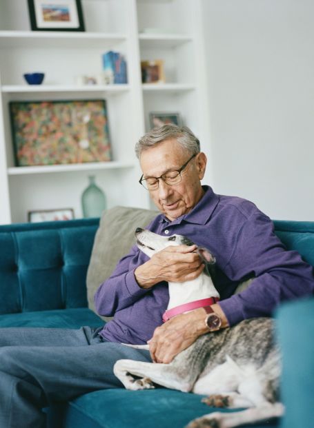 Senior sitting on chair with dog on lap