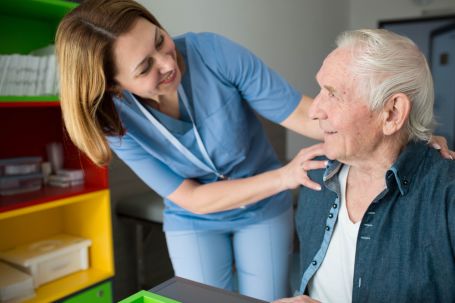 female caregiver checking on male senior to make sure he's doing ok