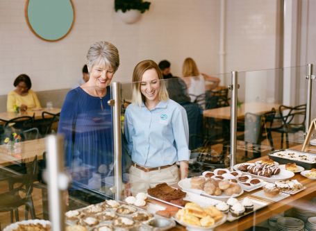 Caregiver and senior ordering coffee from a cafe