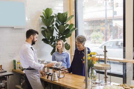 Caregiver and senior ordering coffee from a cafe
