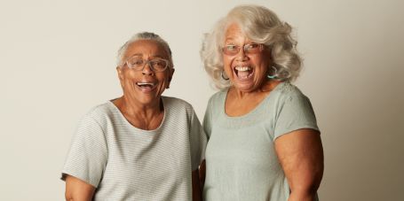 Older women with fluffy furry dog sitting on couch