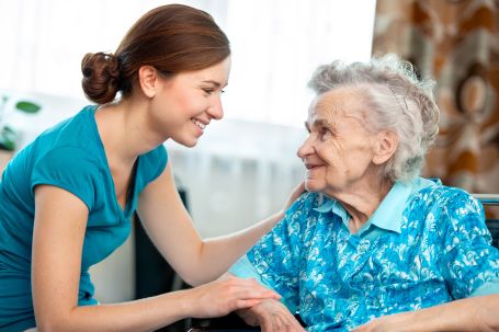 young female caregiver caring for elderly lady 