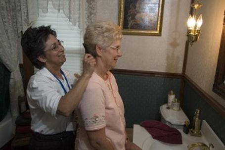 Caregiver assisting senior with hair grooming