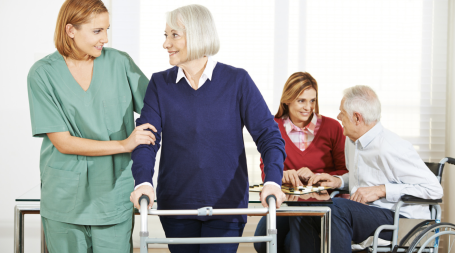 caregiver helping out senior with walker 