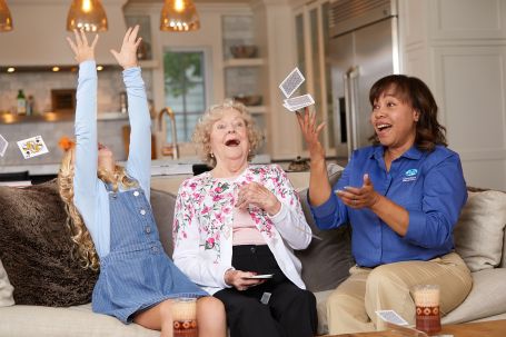 A caregiver shocked as they lose a card game with their client and a child.