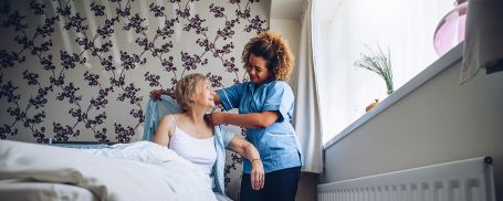 Holly Lake Ranch caregiver dressing senior in senior's home