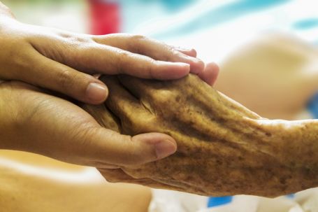Caregiver holding an elderly persons hand