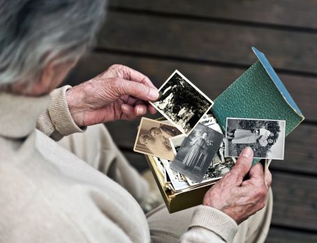 Elderly person with dementia looking at family photos