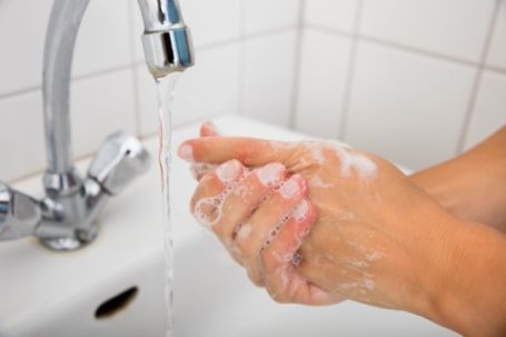 Sugar Land caregiver with soapy hands washing hands at sink