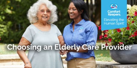Elderly woman being helped by caregiver outside. 