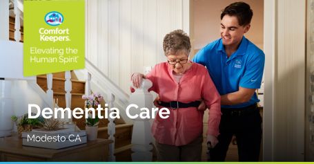 Caregiver helping senior woman down stairs.