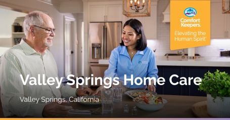 Younger caregiver happily feeding senior man