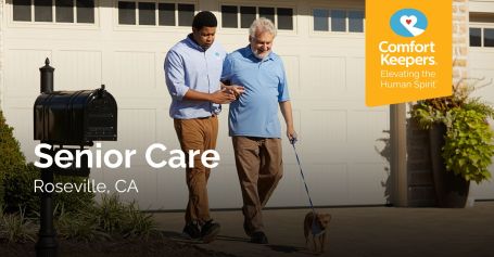 Caregiver walking with senior man and dog