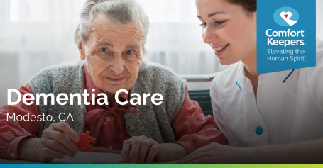 caregiver helping dementia patient with solving a puzzle