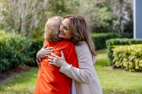 Caregiver and person needing care are sharing a warm embrace.