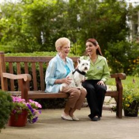 Caregiver and client takes her dog for a walk in the park.