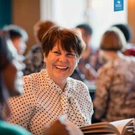 Comfort Keepers client shares a bright smile at a social club event.