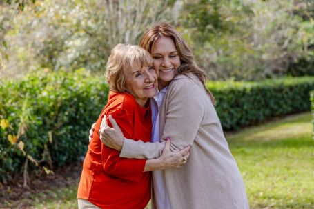 senior hugging daughter