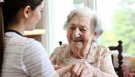 Caregiver smiling caring for an elderly
