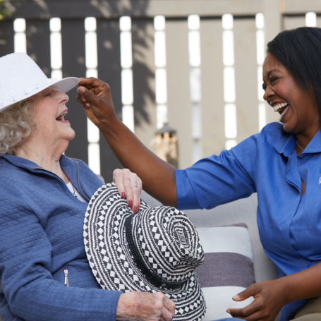 senior woman and caregiver laughing
