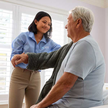Caregiver assisting senior getting dressed in southern pines