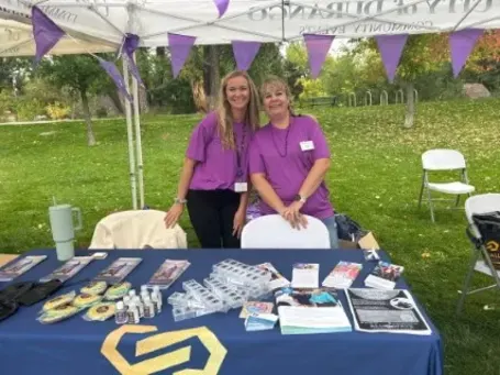 Comfort Keepers representative Jessica Martin with a Cottonwood team member at the Durango Walk to End Alzheimer’s, standing at the awareness booth.