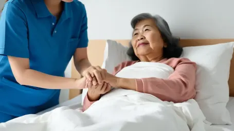 Caregiver holding bed ridden senior's hand