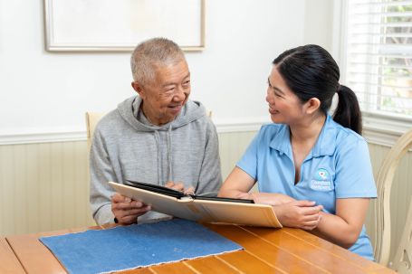 Careprovider smiling and being supportive to an elderly woman
