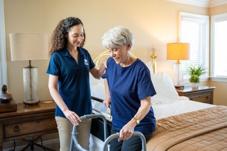Image of caregiver helping senior with walking
